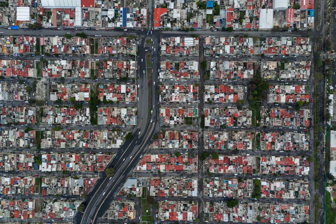 Aerial top-down view of a dense grid of city blocks crossed by a single road