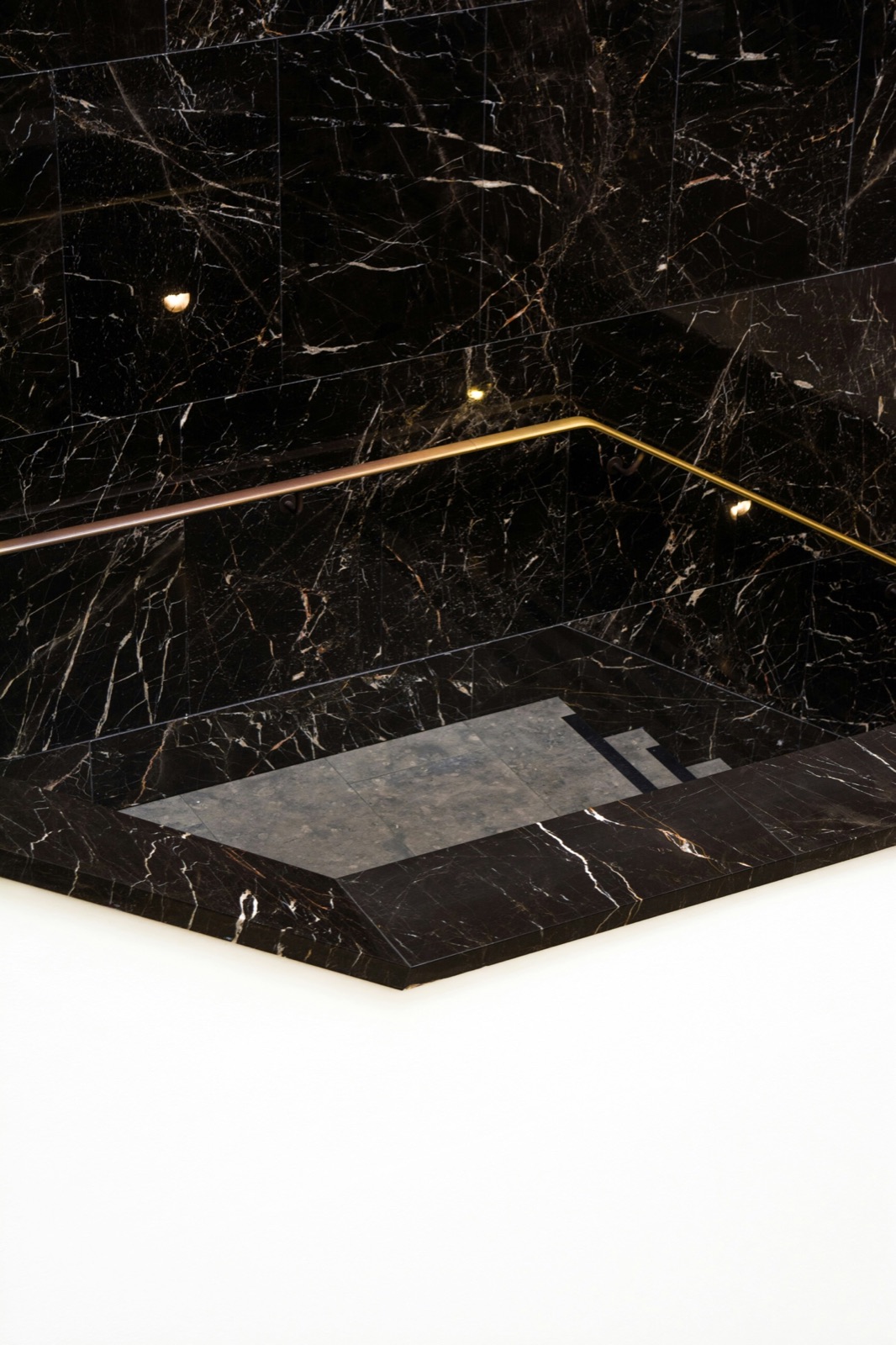 Black marble bath edge with a brass line