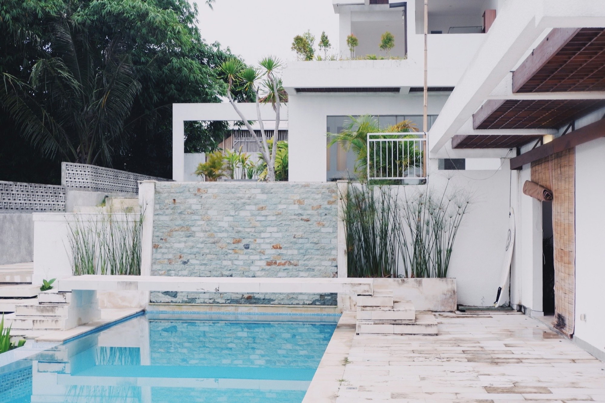 Contemporary white residence with pool against the jungle